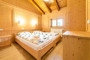 a bedroom with two beds in a wooden room at Ciesa Al Drago in Rocca Pietore
