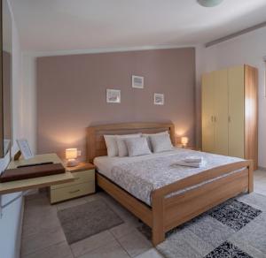a bedroom with a bed and a desk with two lamps at Studio apartman Olivera in Rovinj