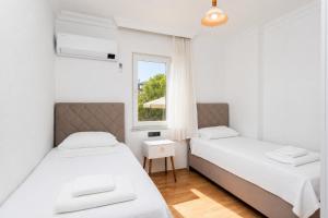 two beds in a room with a window at Daisy Villa in Dalyan