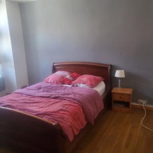 a bed with pink sheets and pillows in a bedroom at Le Pakitoun in Boisse-Penchot