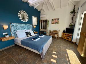 a bedroom with a bed with a blue wall at Espace Harmonie - Gîte Indigo Deshaies in Deshaies