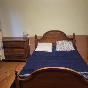 a bedroom with a wooden bed and a dresser at Le Pakitoun in Boisse-Penchot