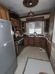 a kitchen with wooden cabinets and a stainless steel refrigerator at شقة سرايا in Irbid