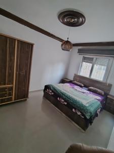 a bedroom with a bed and a cabinet at شقة سرايا in Irbid