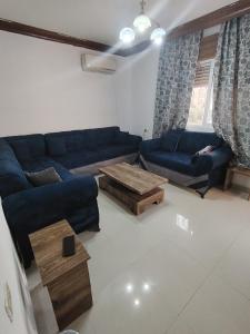 a living room with blue couches and a coffee table at شقة سرايا in Irbid +1 photo