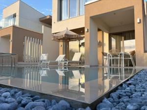 a house with a swimming pool with chairs on it at Calm Luxury Villas in Limenaria
