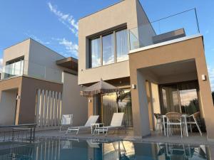 a house with a swimming pool next to a house at Calm Luxury Villas in Limenaria