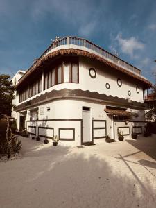 a large white building with a roof at White Maakana Lodge Maldives - all inclusive ed escursioni incluse ogni giorno in Felidhoo 