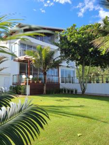 a white building with palm trees in front of it at Casa Cancun Hotel Boutique & Eventos in Penha