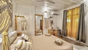 a living room with a bed and a bathroom at White Maakana Lodge Maldives - all inclusive ed escursioni incluse ogni giorno in Felidhoo 