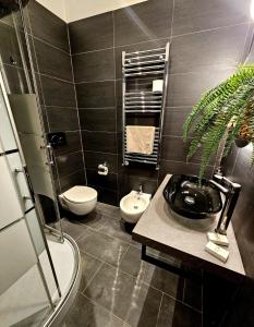 a bathroom with a sink and a toilet and a plant at BARI SOUL old town in Bari