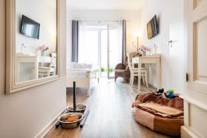 a living room with a couch and a mirror at Hotel Pharisäerhof - DAS Hundehotel auf Nordstrand mit Restaurant und Café in Nordstrand