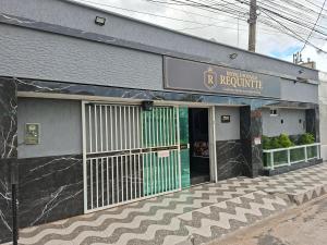 a building with a green door in front of it at Hotel e Pousada REQUINTTE in Parnaíba