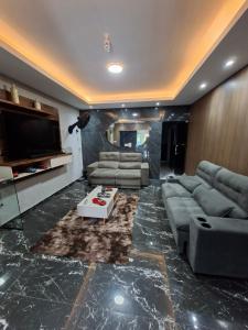 a living room with couches and a flat screen tv at Hotel e Pousada REQUINTTE in Parnaíba