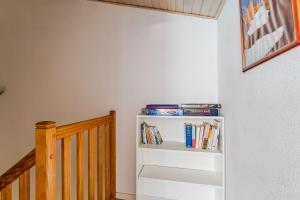 a staircase with a book shelf with books at Appartement 6 p Sanguinet-"Chott" in Sanguinet