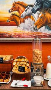a table with a painting of horses on a wall at Hotel Regency Boutique La Feria in Bogotá