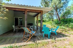 a patio with chairs and a table on a deck at Appartement 6 p Sanguinet-"Chott" in Sanguinet