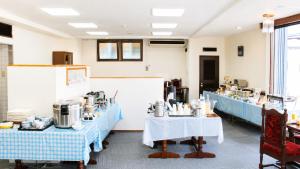 a room with two tables with blue tablecloths at Hotel Higashihiroshima Hills Saijo in Higashihiroshima
