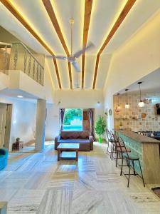 a living room with a couch and a table at Aashiayana Villa - The Dream Stays ll Big Pvt Pool ll 3 Ac rooms ll Wi-fi in Lonavala