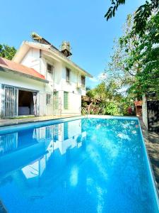 a swimming pool in front of a house at Aashiayana Villa - The Dream Stays ll Big Pvt Pool ll 3 Ac rooms ll Wi-fi in Lonavala