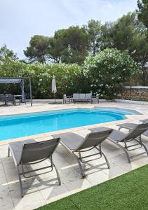 a swimming pool with two chairs and a table at Menorca Villa Marbella in Son Parc