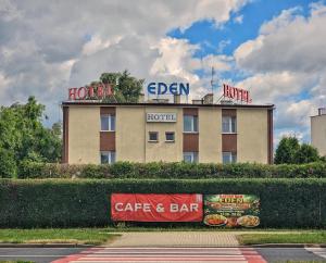 a hotel with signs on top of a building at Hotel Eden 24h in Rzeszów