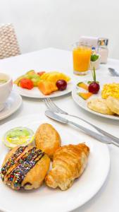 a white table with plates of breakfast food on it at Hotel Regency Boutique La Feria in Bogotá