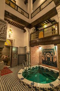 a swimming pool in a building with a tile floor at Riad Lile Fes in Fez