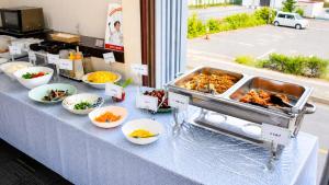 a buffet of food on a table with bowls of food at Hotel Higashihiroshima Hills Saijo in Higashihiroshima