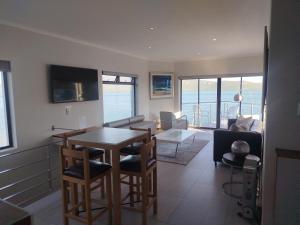 a living room with a table and chairs at Sunset Villa in Langebaan