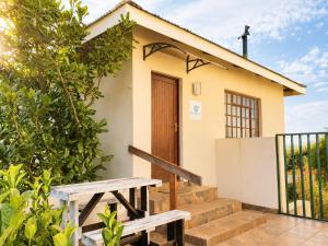 a small house with a wooden door and stairs at Amber Collection in Dullstroom