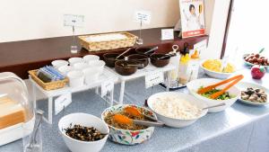 a buffet with bowls of food on a table at Hotel Higashihiroshima Hills Saijo in Higashihiroshima