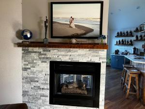 a living room with a fireplace with a tv above it at The Fairway Escape in Hayward