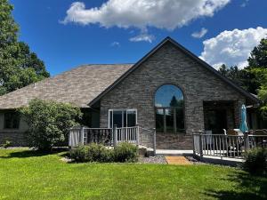 a brick house with a porch and a lawn at The Fairway Escape in Hayward