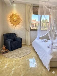 a bedroom with a bed and a chair and a window at Marrakech home in Marrakesh