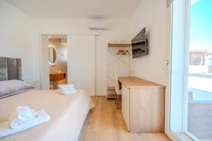 a bedroom with a bed and a desk and a window at Tenuta Bruni - Agriturismo & Pool in Squinzano