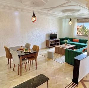 a living room with a table and a green couch at Marrakech home in Marrakesh
