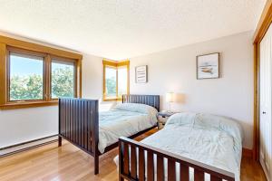 two beds in a room with two windows at Lakefront At Winnipesaukee in Gilford