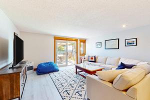 a living room with a couch and a television at Lakefront At Winnipesaukee in Gilford
