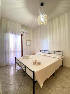 a bedroom with a bed and a chandelier at Bentu e Soli Home Holiday in Villasimius