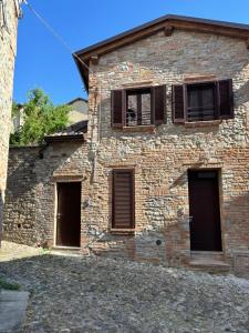 a brick building with three doors and windows at Casa LEONARDO in CastellʼArquato