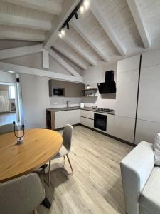 a living room with a wooden table and a kitchen at Casa LEONARDO in CastellʼArquato