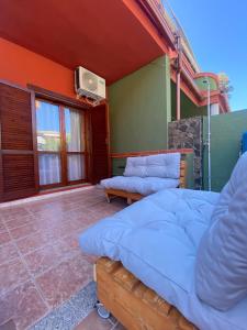 a bedroom with two beds and a tv on the wall at Bentu e Soli Home Holiday in Villasimius