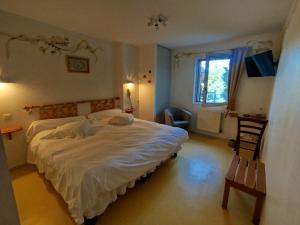 a bedroom with a large white bed and a window at Hôtel Restaurant Le Regimbal in Javols