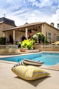 a yellow and white pillow sitting next to a swimming pool at La Demeure du Bord'Ô in Lagruère