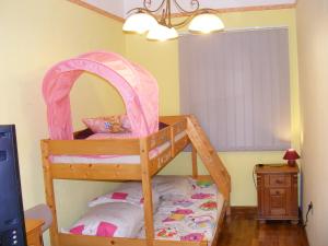a bedroom with a bunk bed with a pink canopy at Négy Gólya in Sarud