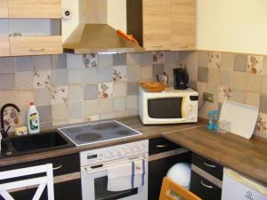 a small kitchen with a microwave and a stove at Négy Gólya in Sarud