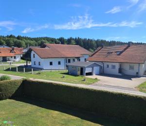 a group of houses in a yard with a hedge at Haus Probst in Bischofsmais
