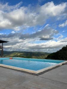 a large swimming pool with a cloudy sky in the background at Finca Mirador De Gualaca in Gualaca