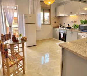 a kitchen with a table and a white refrigerator at Marrakech in Marrakesh